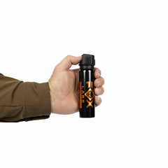 A person in a brown jacket holds a Fox Labs One Point Four 3oz Pepper Spray canister with orange text and a fox logo on a black container, shown against a plain white background.