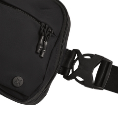 Close-up of the Vertx Everyday Fanny Pack+ by Vertx, featuring a black design with a zippered pocket, double zipper pulls, round Vertx logo, and plastic side-release buckle on a wide strap against a white background.