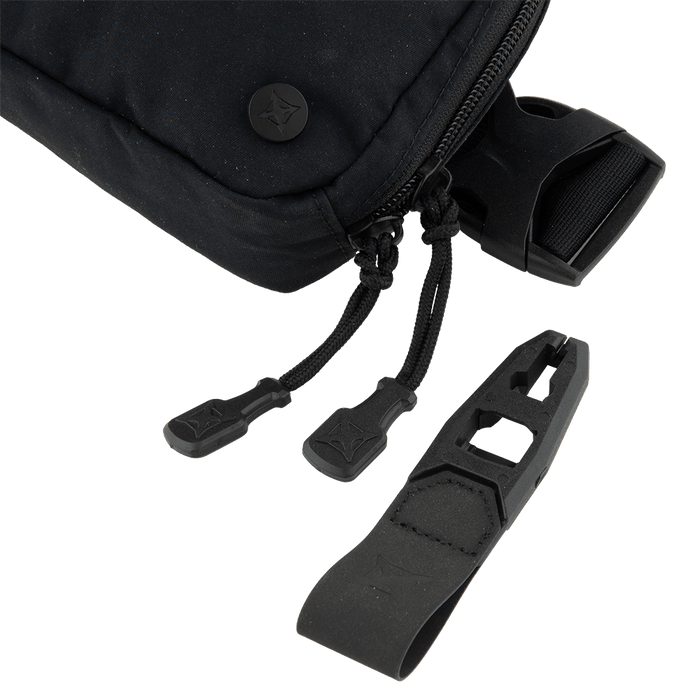 A close-up of the Vertx Everyday Fanny Pack 2.0 by Vertx shows its black zippered design with dual zipper pulls and a detachable black plastic looped attachment with geometric cutouts, all displayed against a white background.