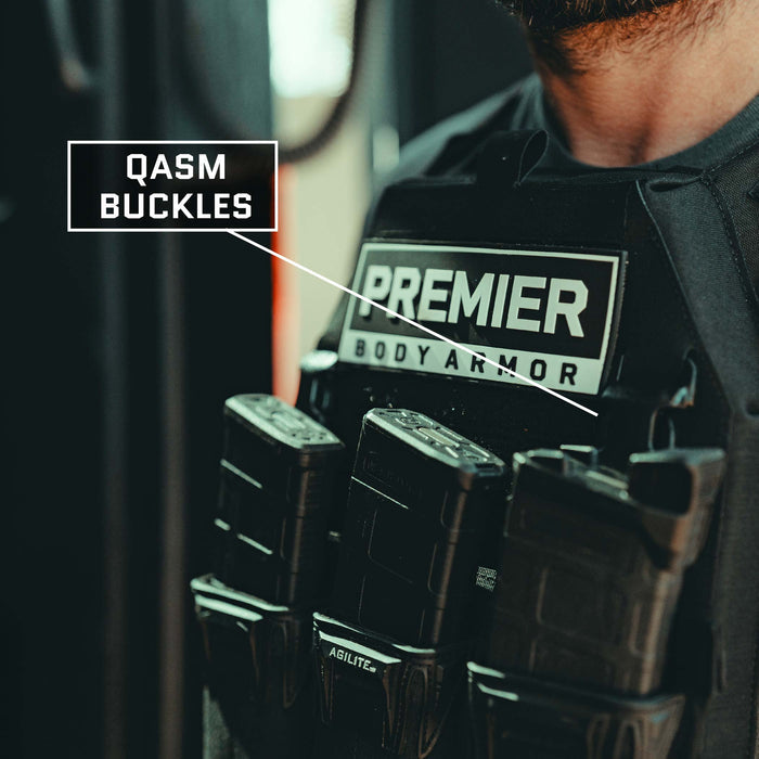 Close-up of a person wearing the Premier Body Armor Fortis Level IV Loadout vest, featuring labeled QASM buckles. The Fortis Alpha Carrier part of the vest includes multiple magazine pouches filled with magazines, offering tactical flexibility. The person's face is not visible in the image.