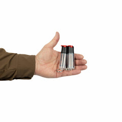 A person in a brown sleeve holds two Fox Labs FoxFire Inferno Twin Pack pepper spray canisters with black caps and red tops in their palm against a white background.