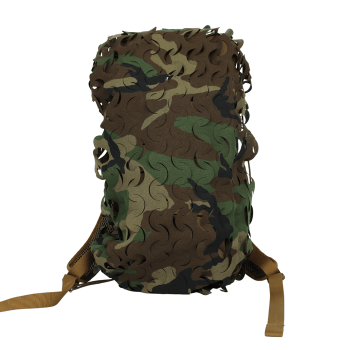 The OPE Gear Backpack Scrim - Camouflage Pack Cover by OPE Gear in M81 Woodland covers a backpack with tan shoulder straps, made from durable Cordura nylon and shown standing upright against a plain white background.