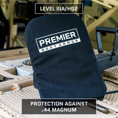 A black Premier Body Armor Level IIIA Insert for 5.11 Rush 24/72 Pack with a para-aramid core is displayed on a tan vehicle. "Level IIIA/HG2" text marks protection per NIJ standards, defending against .44 Magnum rounds.