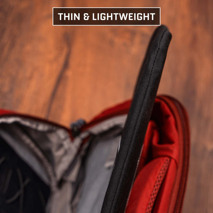 A Premier Body Armor 9 x 13.5 Insert Level IIIA Armor (Multicam Black) is being placed in a red backpack’s open compartment, with "THIN & LIGHTWEIGHT" shown at the top—providing discreet ballistic protection.