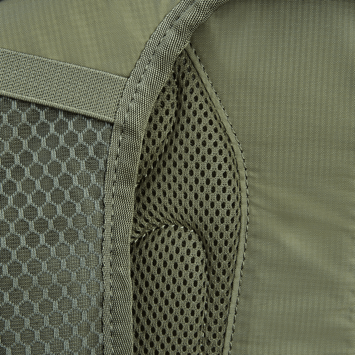 Close-up of the Vertx Long Walks Pack 28L, featuring a green backpack with a left mesh pocket and textured gray stripe. The fabric has honeycomb on one side and smooth on the other, perfect for adding body armor inserts for extra safety.