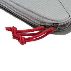 Close-up image of the Vertx Pack Organizer Large, a gray fabric pouch with a zipper. The zipper features two red rope pulls tied in knots. The fabric texture and stitching details are clearly visible, making it ideal for use with loop-lined bags from Vertx. The background is plain white.